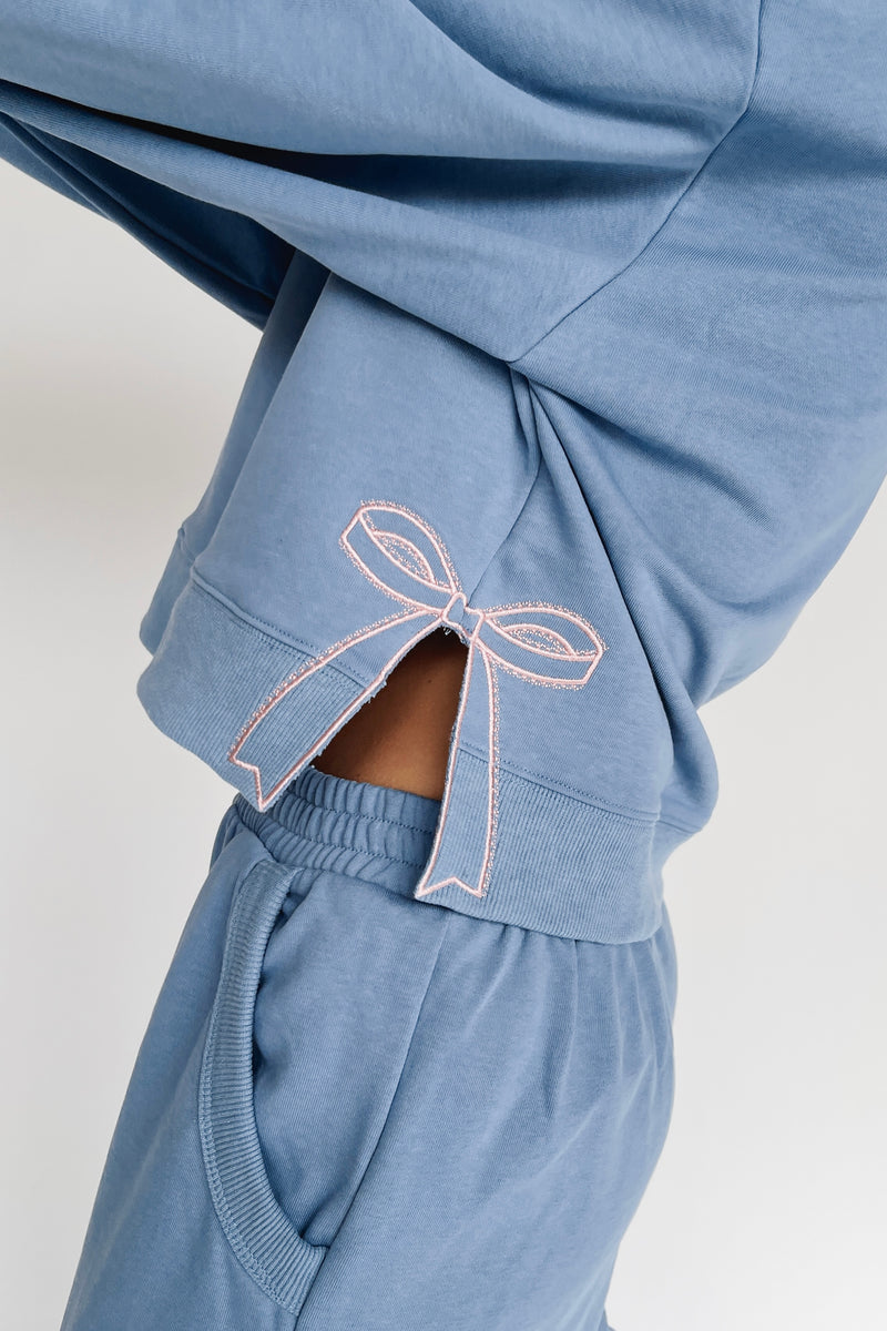 The Monzingo Bow Embroidered Pullover in Dusty Blue